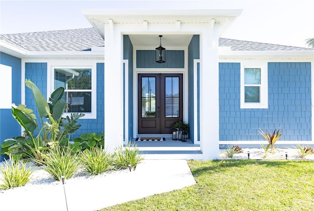 entrance to property featuring a lawn and french doors