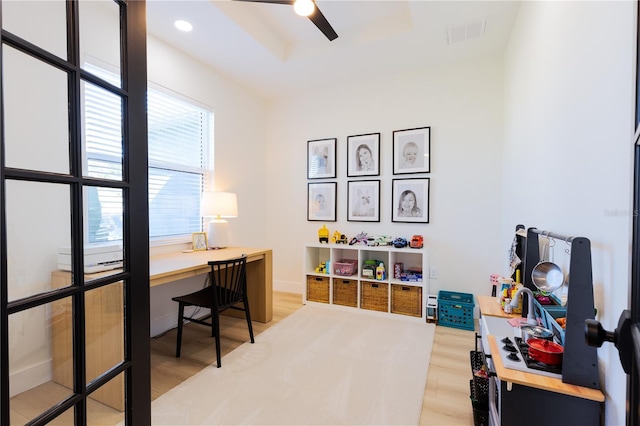 office with wood-type flooring, ceiling fan, and a tray ceiling