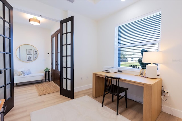 office area with light wood-type flooring and french doors