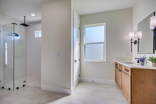 bathroom with tiled shower, vanity, and tile patterned flooring