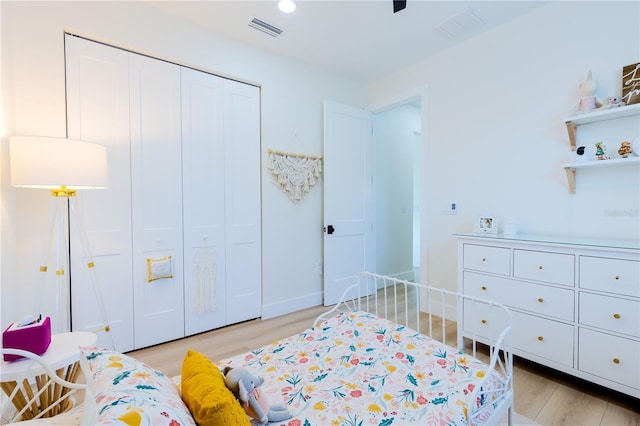 bedroom with light hardwood / wood-style flooring and a closet