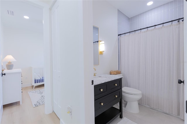 bathroom with vanity, walk in shower, tile patterned floors, and toilet