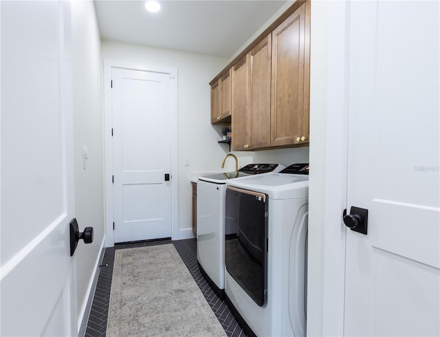 laundry area featuring independent washer and dryer, cabinets, and dark tile patterned flooring