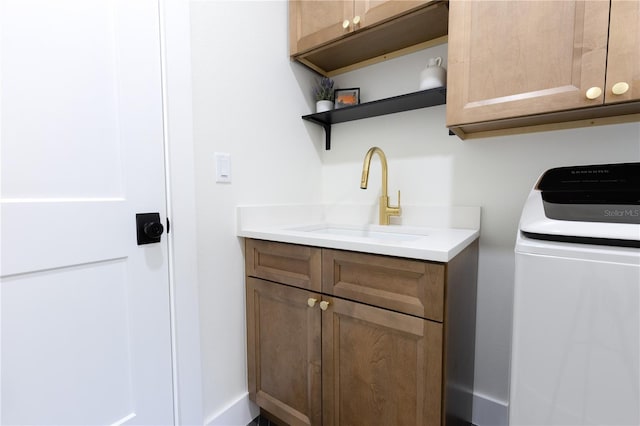 washroom featuring washer / clothes dryer, sink, and cabinets