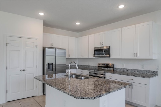 kitchen featuring appliances with stainless steel finishes, a kitchen island with sink, sink, and white cabinets