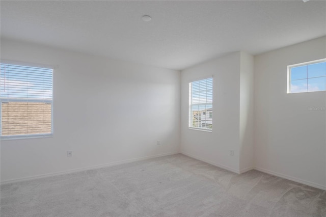 unfurnished room featuring light colored carpet