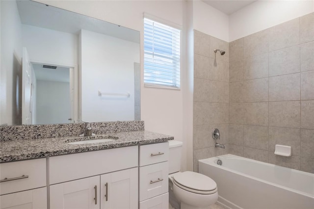 full bathroom with tiled shower / bath combo, vanity, and toilet