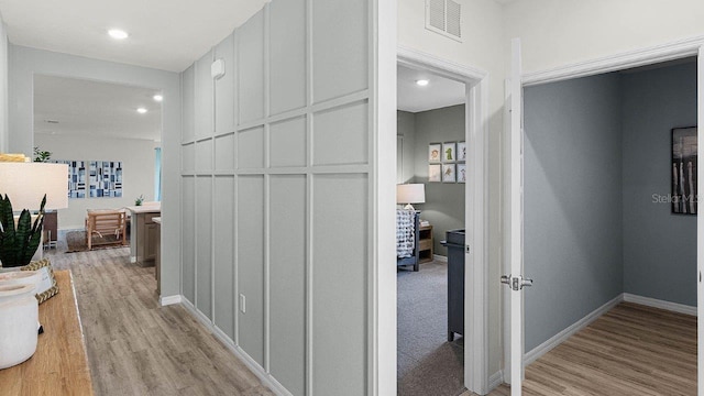 hallway with light hardwood / wood-style floors