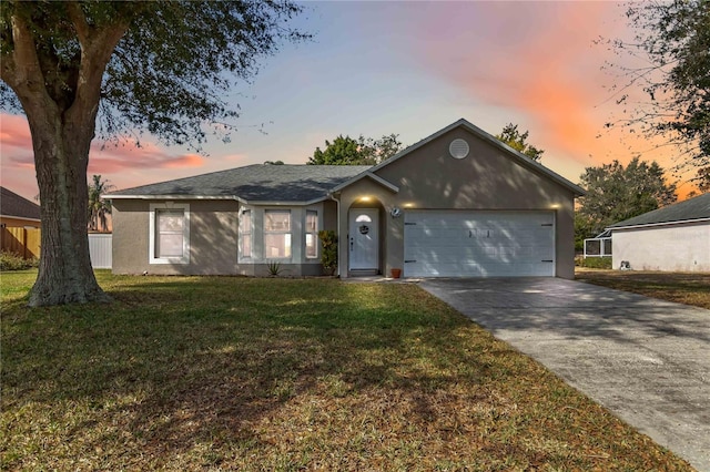 single story home with a garage and a lawn