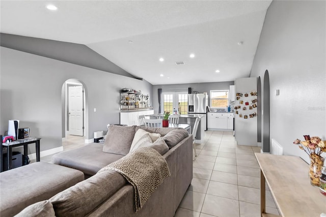 living room with vaulted ceiling and light tile patterned flooring