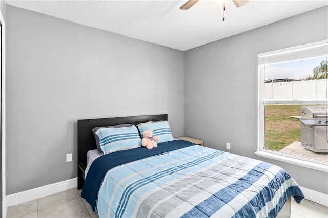 bedroom featuring light tile patterned floors, a textured ceiling, and ceiling fan