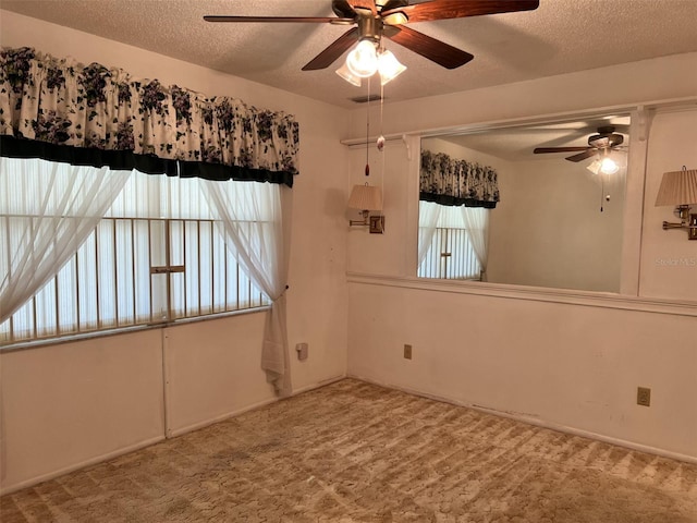 carpeted spare room featuring ceiling fan, plenty of natural light, and a textured ceiling