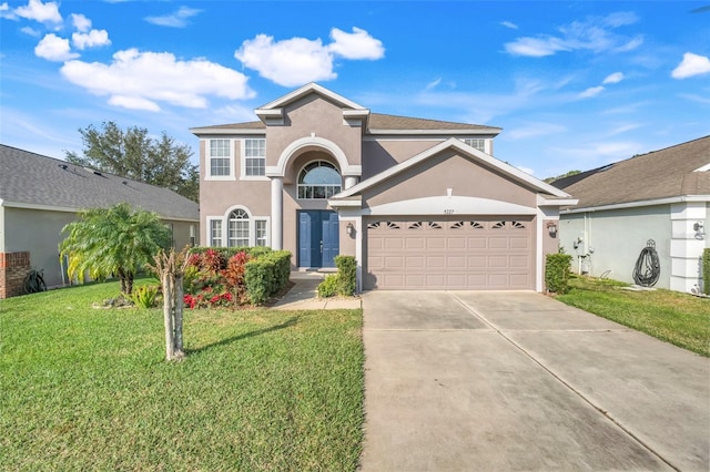 view of property with a garage and a front lawn