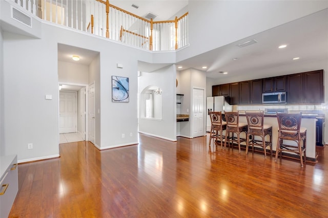 dining area featuring a high ceiling and hardwood / wood-style floors