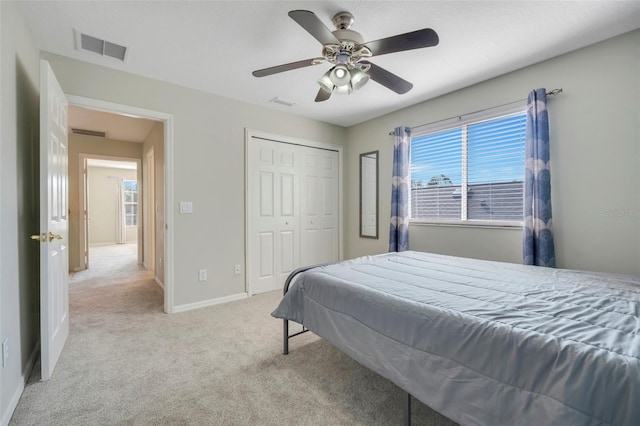 carpeted bedroom with ceiling fan and a closet