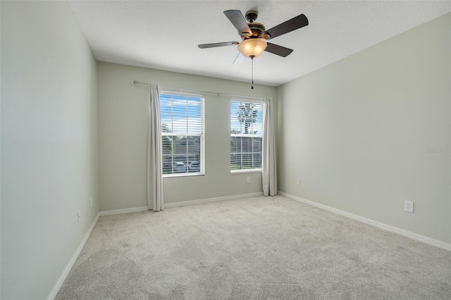 spare room featuring light carpet, a textured ceiling, and ceiling fan