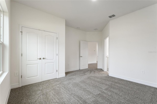 unfurnished bedroom with carpet floors and a closet