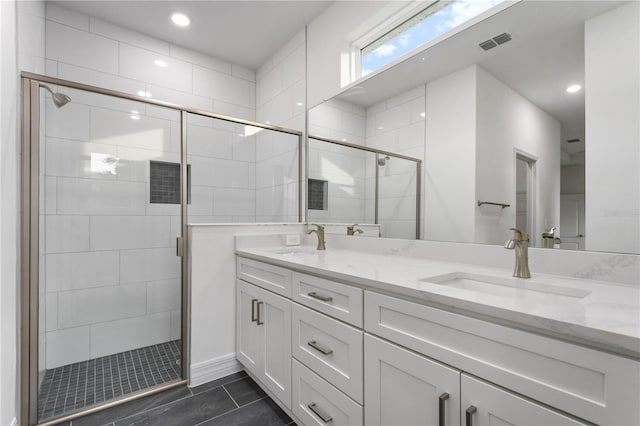 bathroom featuring tile patterned floors, vanity, and a shower with door