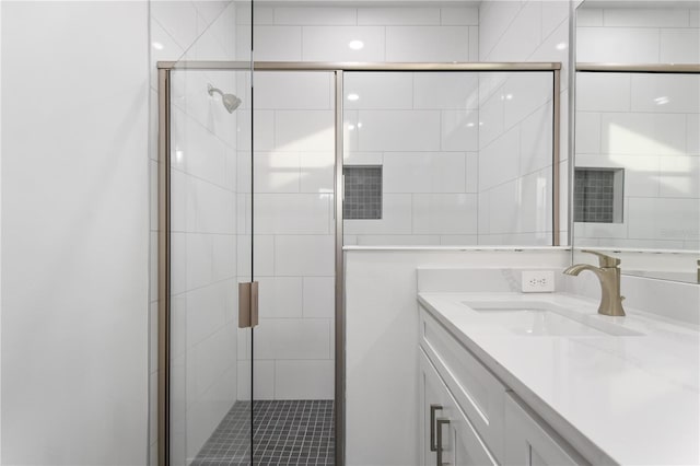 bathroom featuring vanity and a shower with door