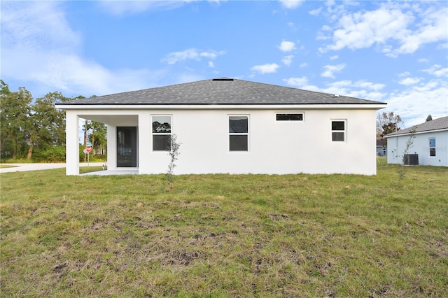 rear view of house featuring a lawn and central air condition unit