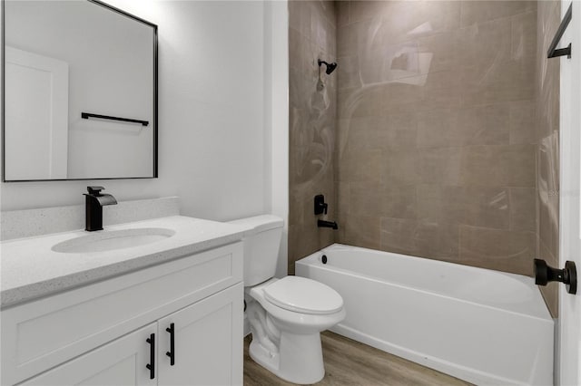 full bathroom with tiled shower / bath combo, vanity, hardwood / wood-style floors, and toilet