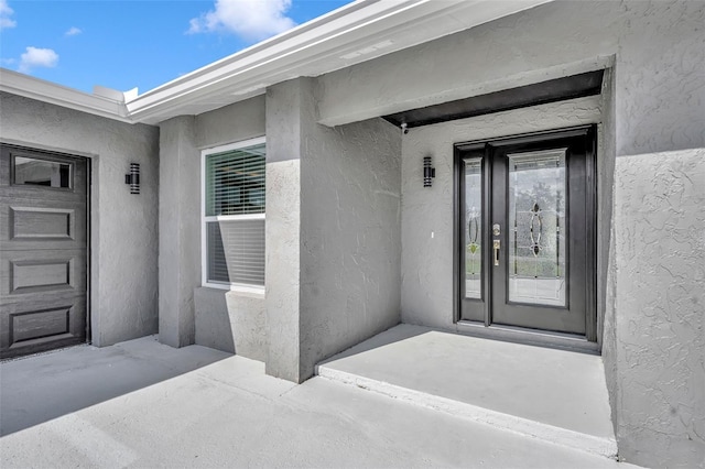 property entrance featuring stucco siding