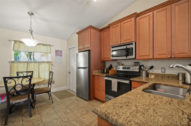 kitchen featuring vaulted ceiling, decorative light fixtures, sink, stainless steel appliances, and a textured ceiling