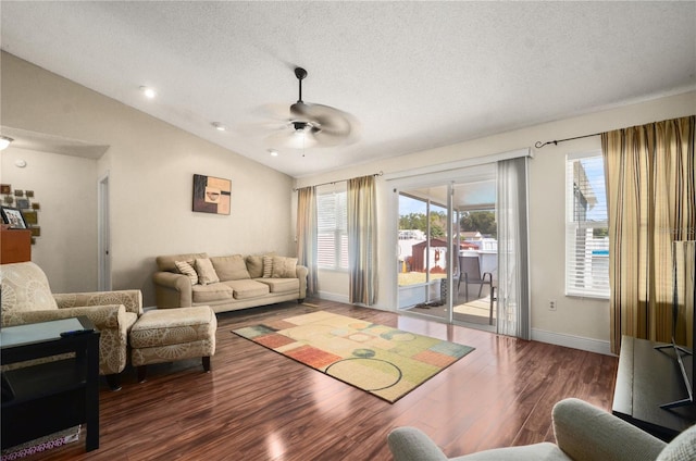 living room with vaulted ceiling, dark wood-type flooring, a textured ceiling, and ceiling fan