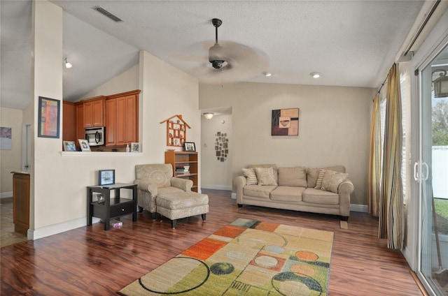 living room with lofted ceiling, hardwood / wood-style floors, a textured ceiling, and ceiling fan