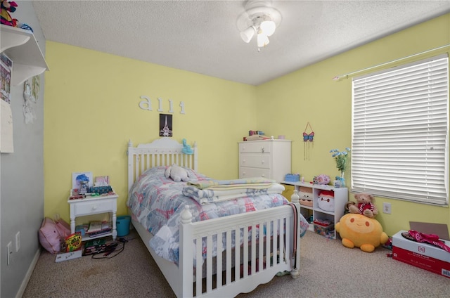 carpeted bedroom featuring ceiling fan and a textured ceiling