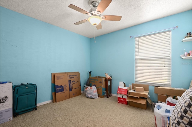 game room with ceiling fan, carpet flooring, and a textured ceiling