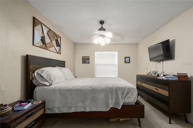 carpeted bedroom featuring ceiling fan and a textured ceiling