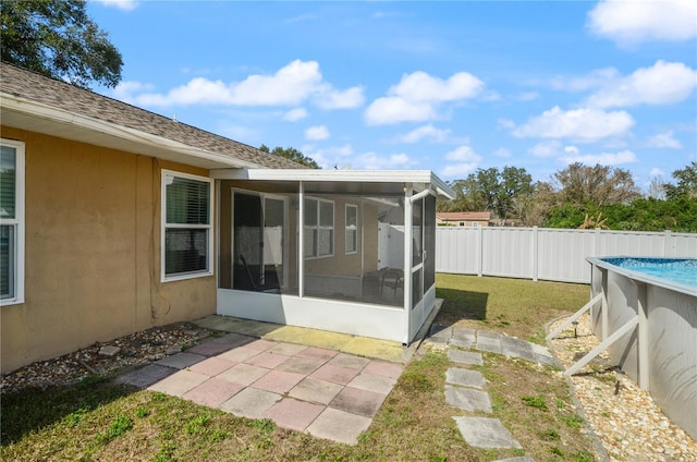 view of yard featuring a fenced in pool and a sunroom