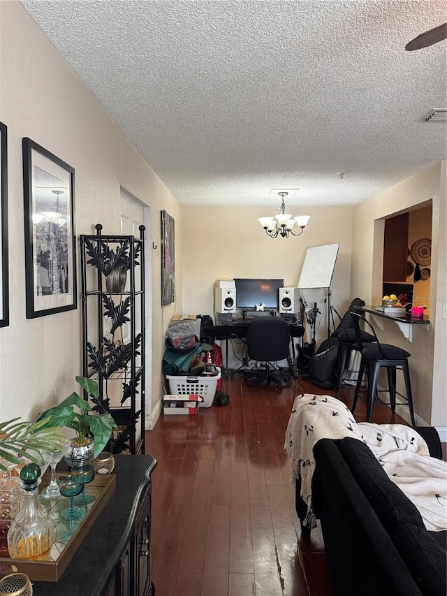 living room with dark hardwood / wood-style floors, a textured ceiling, and a chandelier