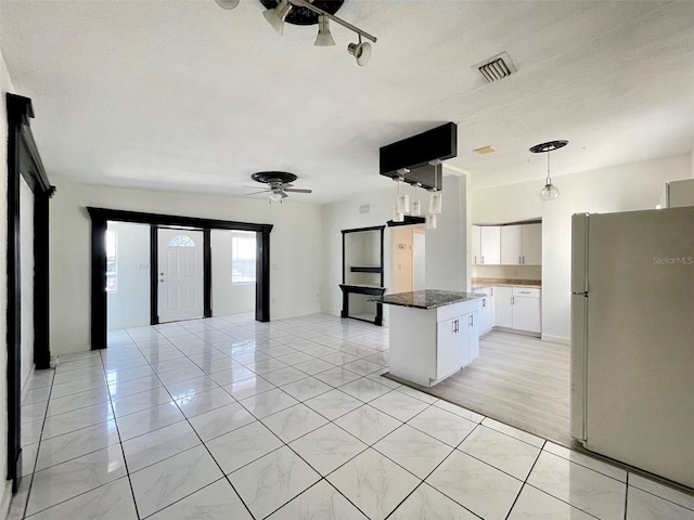 kitchen with ceiling fan, a center island, white cabinets, decorative light fixtures, and white fridge