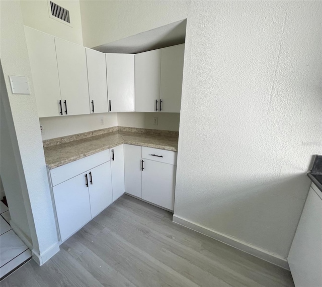 kitchen with white cabinetry and light hardwood / wood-style floors