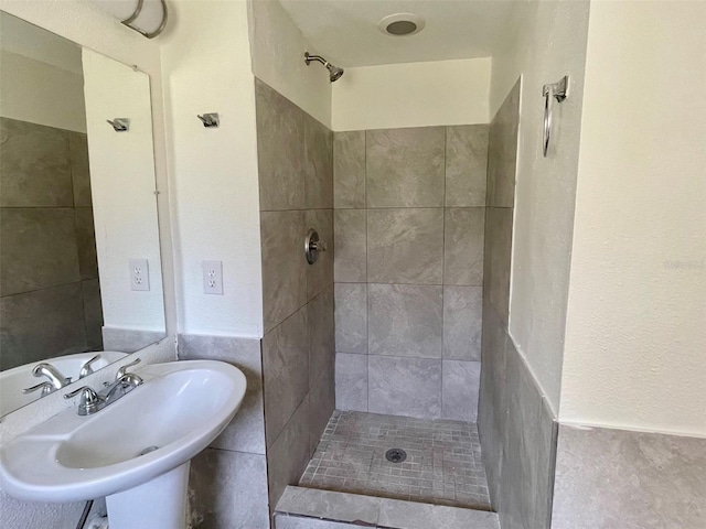 bathroom featuring a tile shower and sink