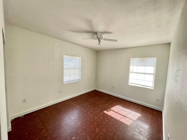 unfurnished room with ceiling fan and a textured ceiling