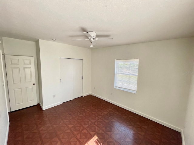 unfurnished bedroom with ceiling fan, a textured ceiling, and a closet