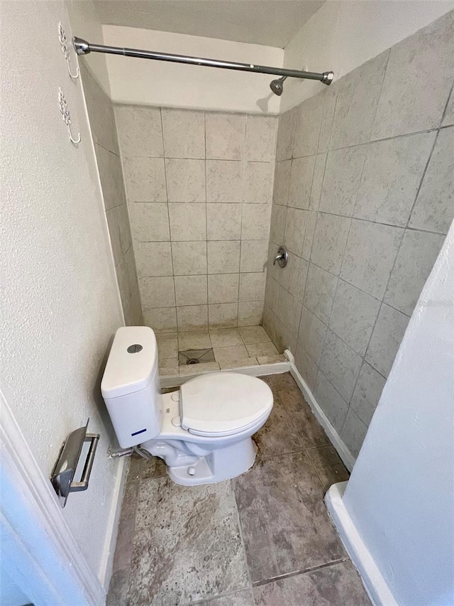 bathroom with toilet and tiled shower