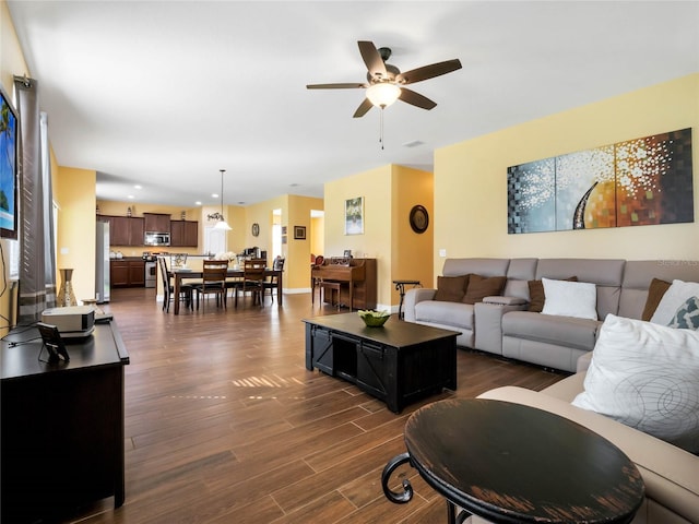 living room featuring dark wood-type flooring and ceiling fan