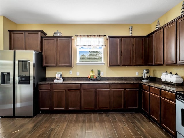 kitchen with stainless steel refrigerator, dark brown cabinetry, and dark wood-type flooring