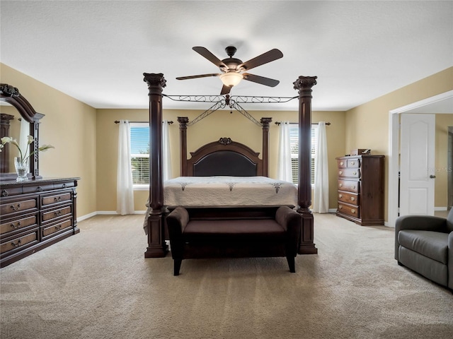 bedroom with ceiling fan, light colored carpet, and multiple windows