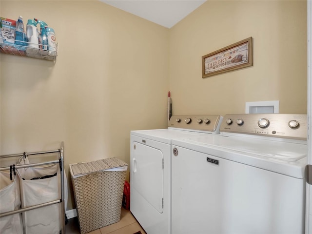 laundry area featuring light tile patterned flooring and washing machine and dryer