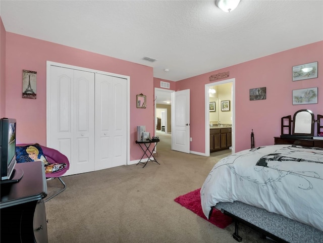 bedroom with light colored carpet, a closet, and a textured ceiling