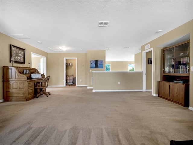 carpeted living room featuring a textured ceiling