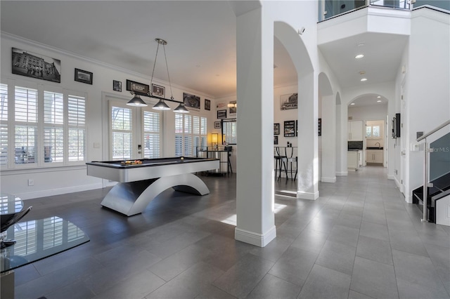 playroom featuring pool table, ornamental molding, and a high ceiling