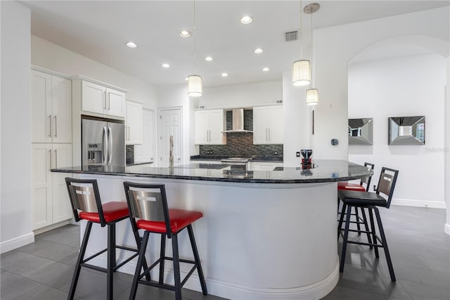 kitchen with white cabinetry, a spacious island, stainless steel appliances, and wall chimney exhaust hood