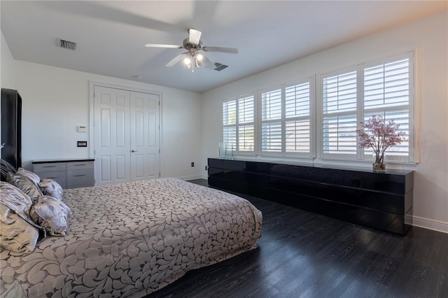 bedroom with a closet, dark hardwood / wood-style floors, and ceiling fan