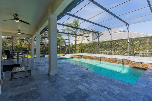 view of pool featuring pool water feature, ceiling fan, a patio, and glass enclosure